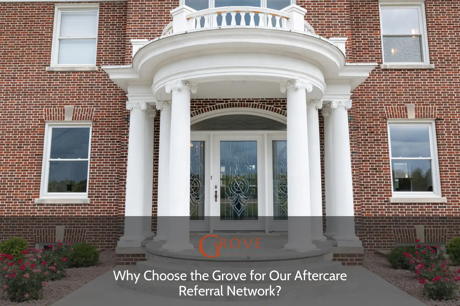 Elegant entrance featuring white columns and intricately designed double doors, surrounded by blooming flower beds, inviting visitors to the Grove aftercare network.