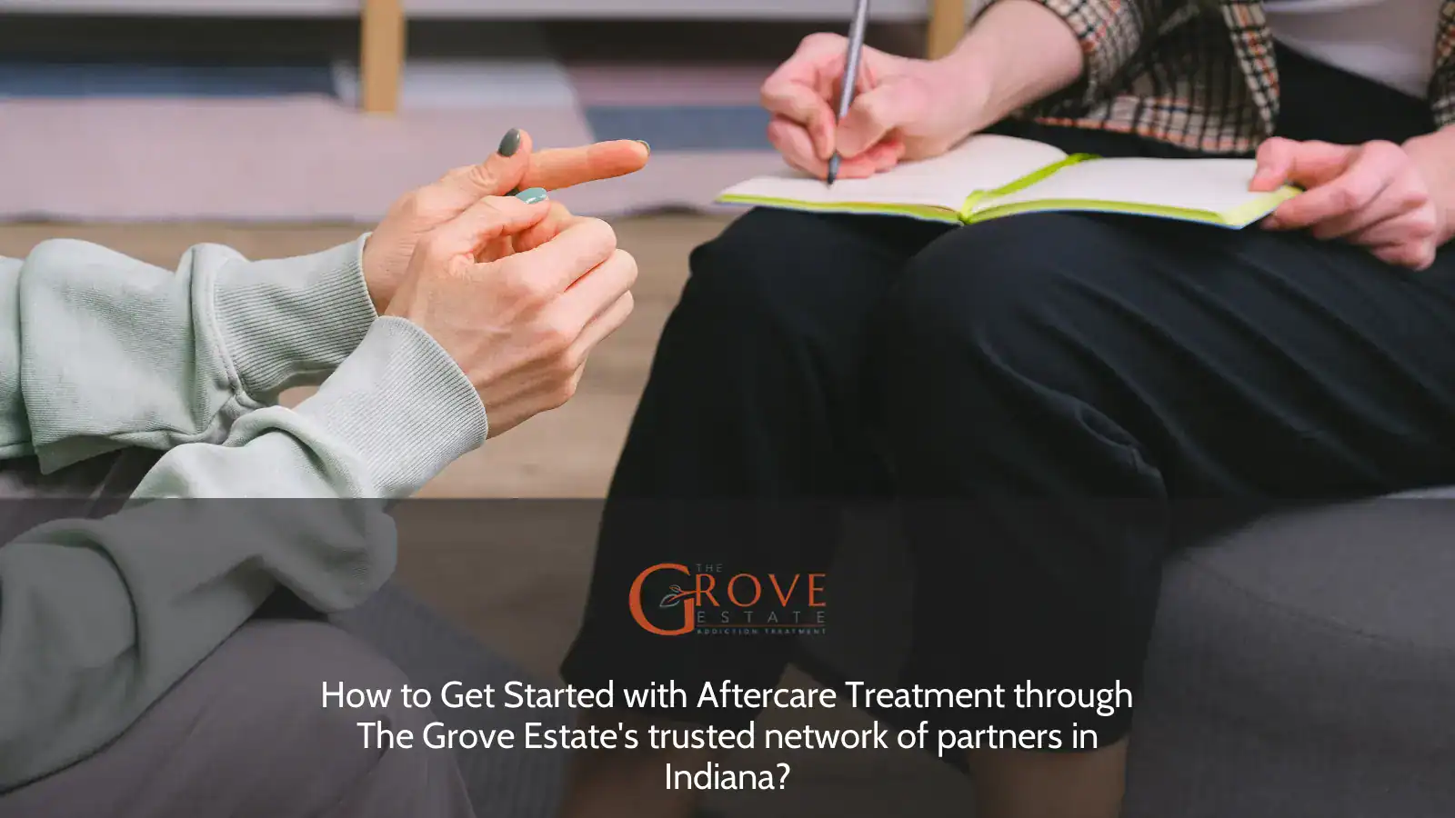 Discussing aftercare treatment, a person takes notes while another gestures, emphasizing the importance of support in recovery at The Grove Estate, Indiana.