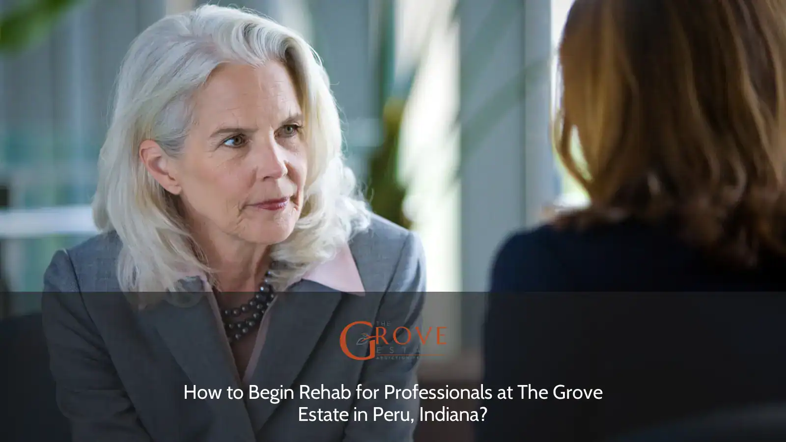 A professional woman with silver hair listens intently during a consultation about rehab methods at The Grove Estate in Peru, Indiana.
